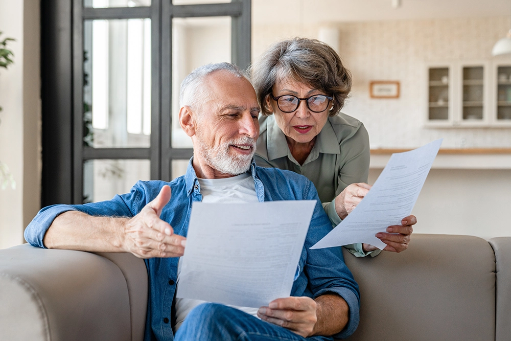 Senior couple reviewing comparing documents Senior couple reviewing comparing documents