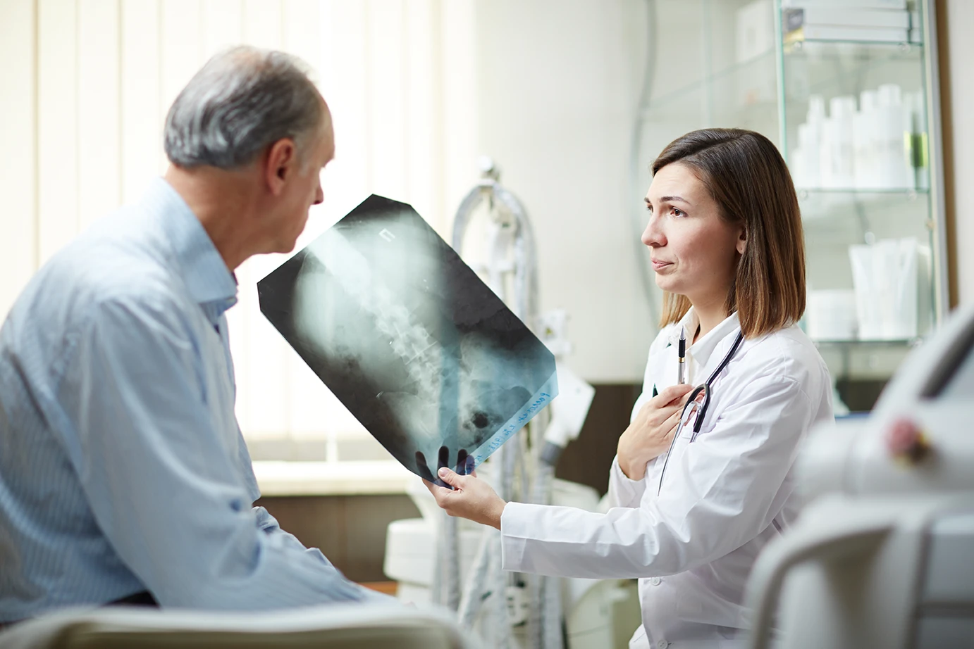 Doctor reviewing medical imaging to determine aggravation versus exacerbation of a pre-existing injury after an accident