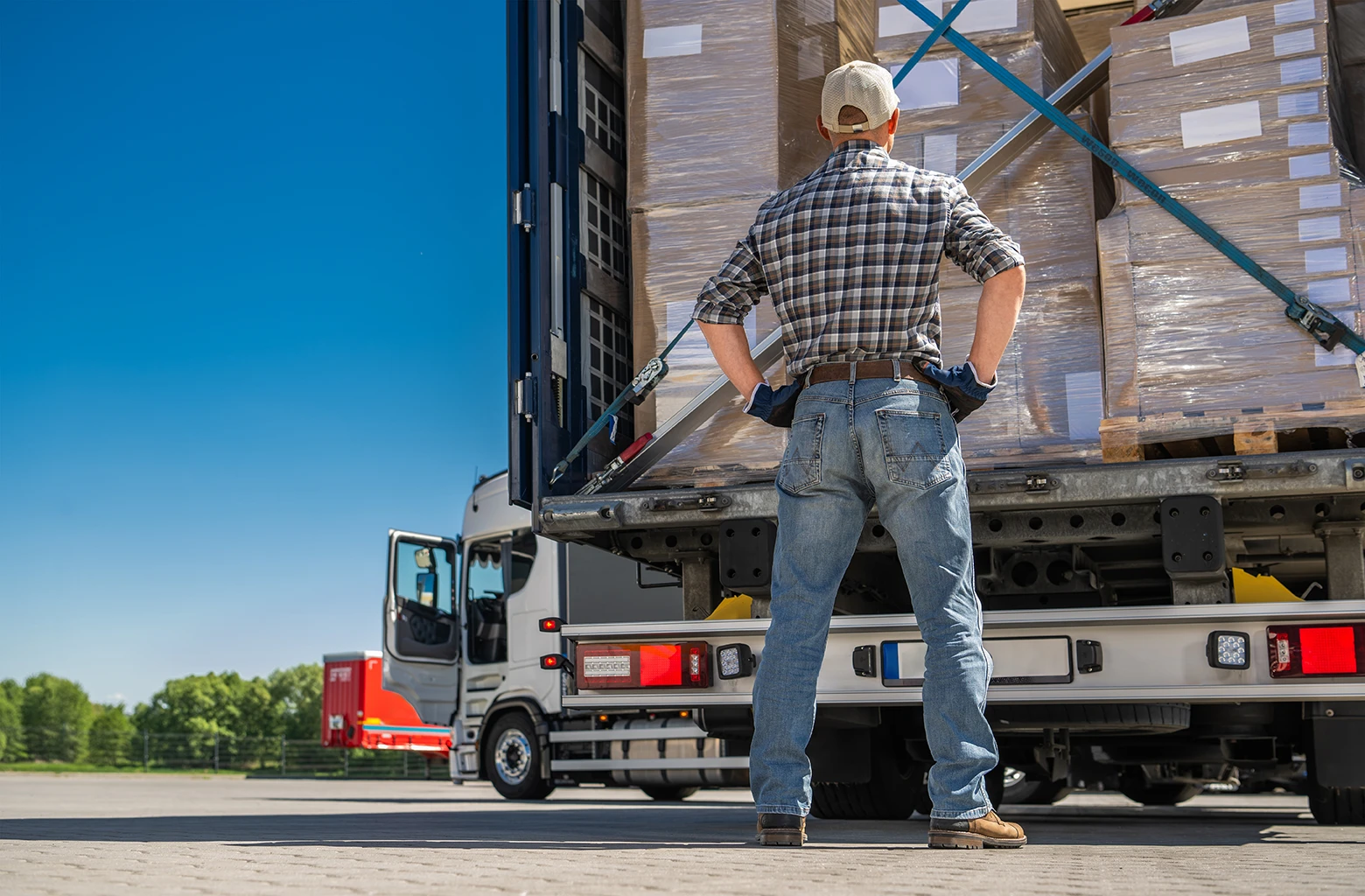 Overloaded commercial truck with improperly secured cargo showing cargo violation risk on highway