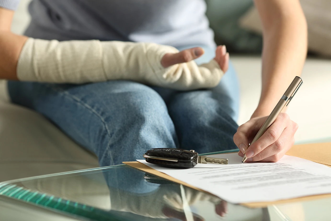 Injured worker reviewing bills and employment paperwork after a car accident