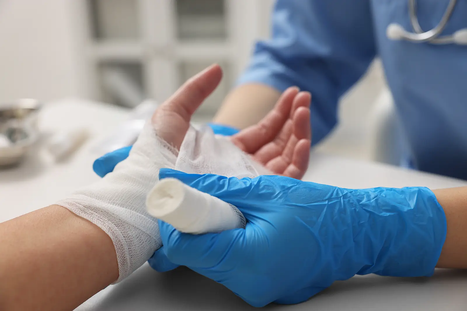 Medical professional bandaging a patient’s hand after a serious burn injury