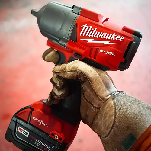 Gloved hand holding a cordless power tool