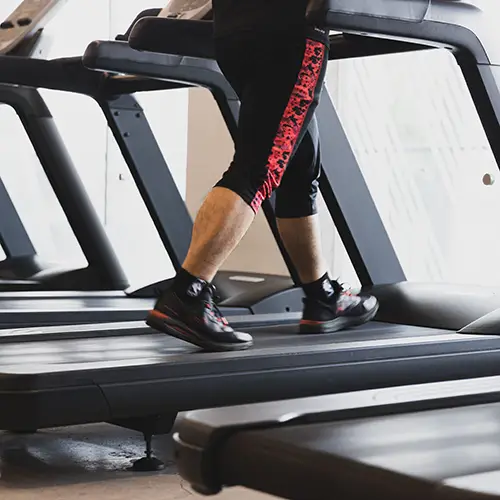 Person walking on a treadmill in a gym